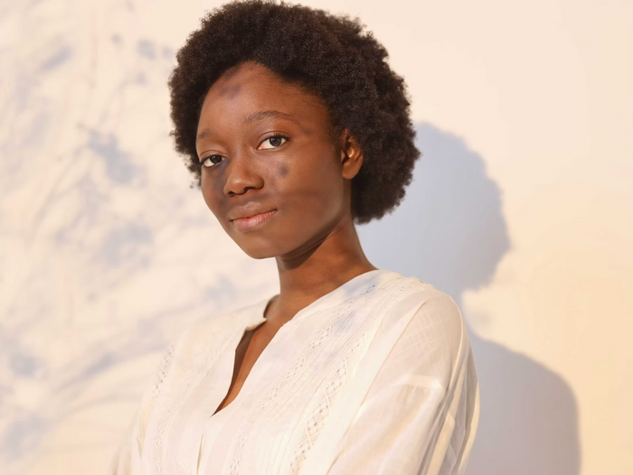 Frau mit Afro zur Golden Hour vor weißen Hintergrund