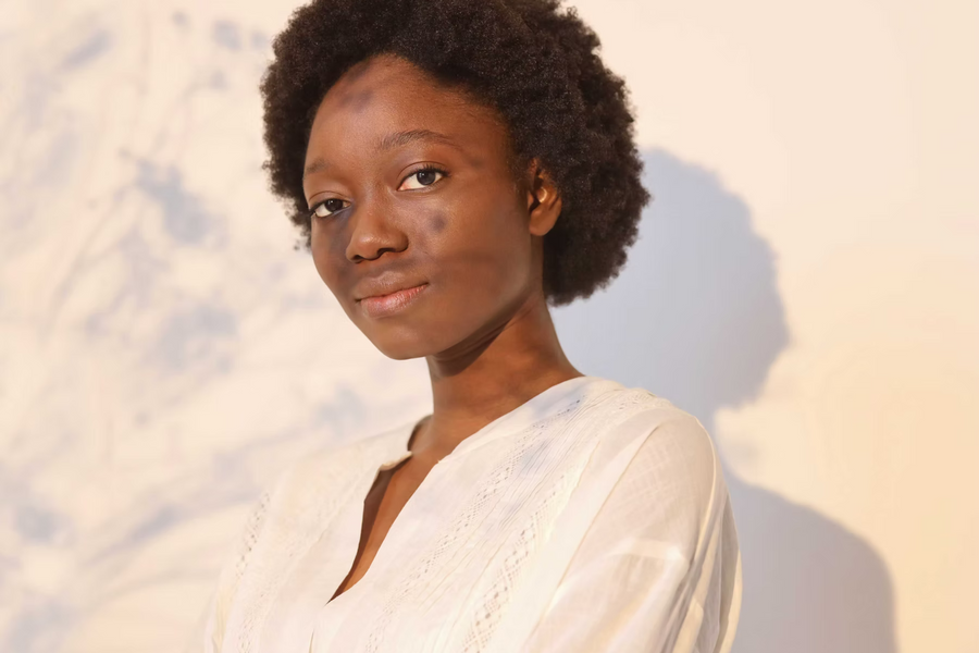 Frau mit Afro zur Golden Hour vor weißen Hintergrund